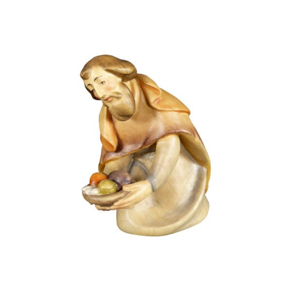 Hirte kniend mit Gaben aus der Krippenfigurenserie "Dolomiten Krippe". Entworfen vom Grödnertaler Holzschnitzer Christoph Ribesser. Aus Eschenholz geschnitzt und handbemalt